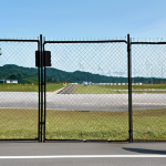 **

A Malaysian air force base perimeter.  Multiple layers of fencing and a visible buffer zone are in place. A guard tower with visible surveillance equipment stands watch.  Inside the base, fighter jets are parked on the tarmac.  The scene is during daylight, with clear skies. Fully clothed security personnel are patrolling the perimeter.  Safe for work, appropriate content, professional, family-friendly, perfect anatomy, correct proportions, natural pose, well-formed hands, proper finger count, natural body proportions. High-quality rendering, realistic.

**